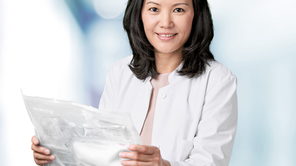 A female health care professional holds a 3-chamber bag