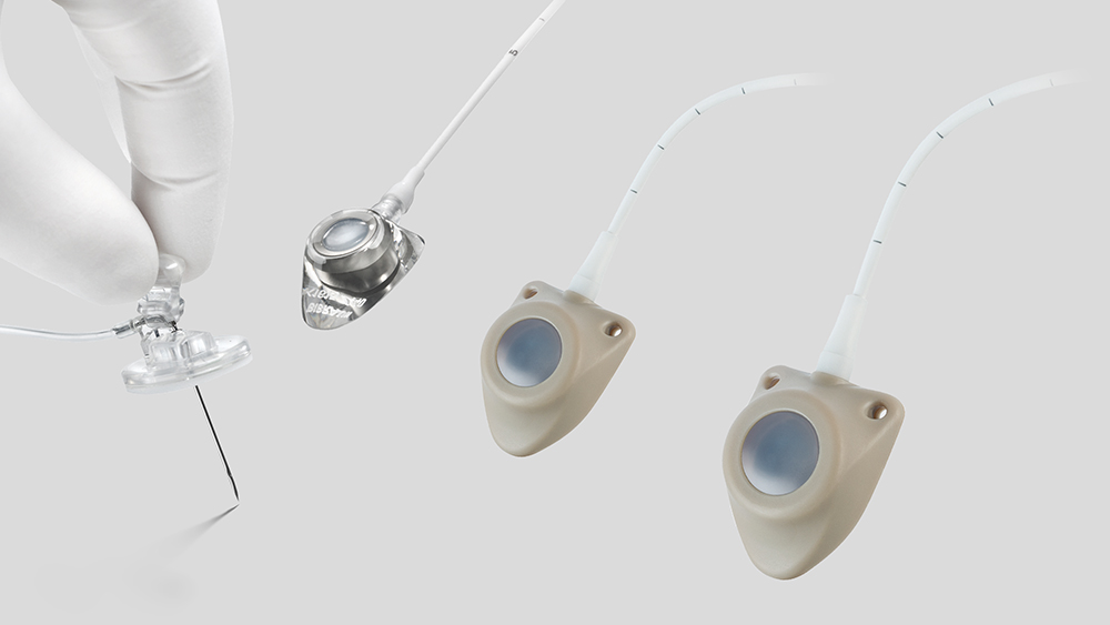 Left side: Hand in white gloves holding port needle tip downwards. Three IV ports with connected drain on the right side of the picture.