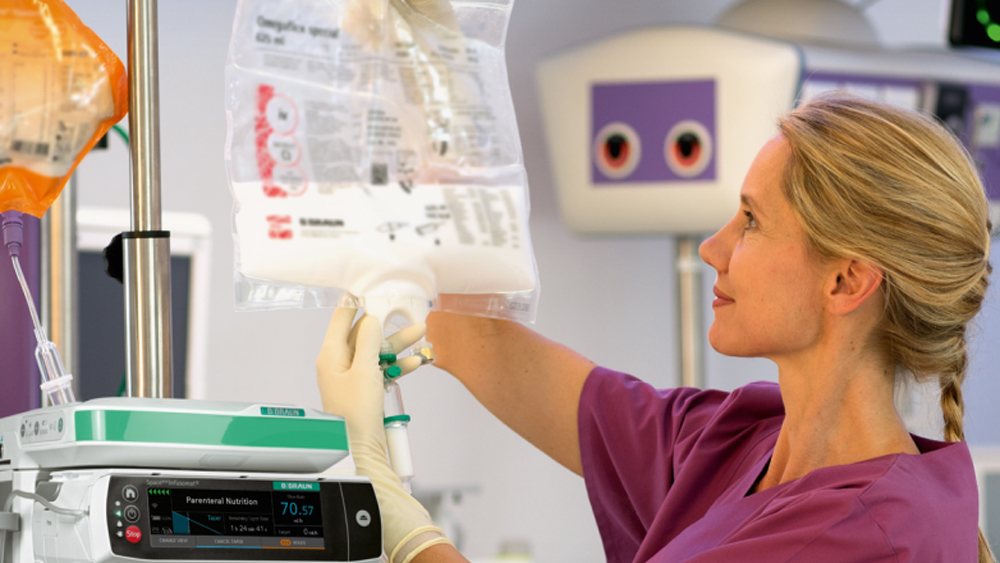 A nurse hangs up a three-chamber bag